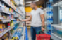 Supermarket shopper examines product from shelf