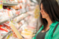 woman checking grocery product.png