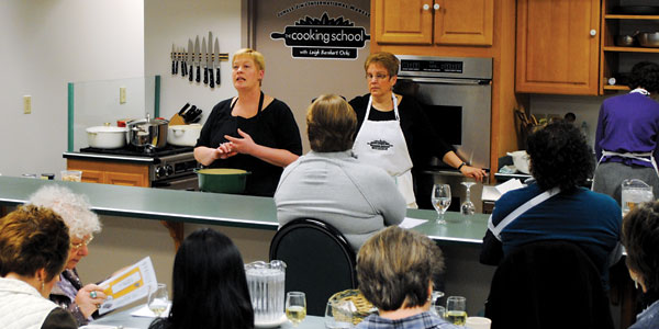Leigh Barnhart Ochs (left) discusses a recipe with students at Jungle Jim’s cooking school.