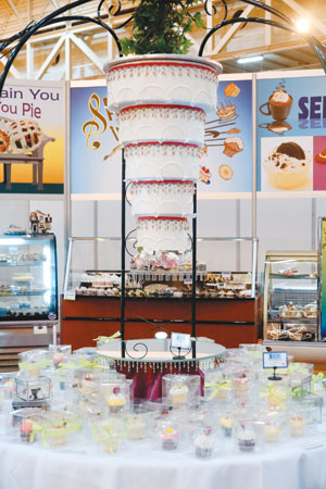 An upside-down wedding cake calls attention to a bakery display. 