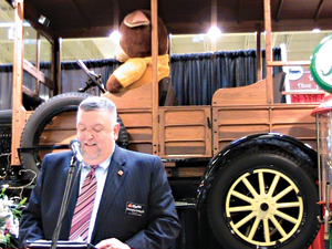 A 1926 Ford Model T serves as a backdrop as Christopher Kinsley Sr. speaks at the grand opening event. 